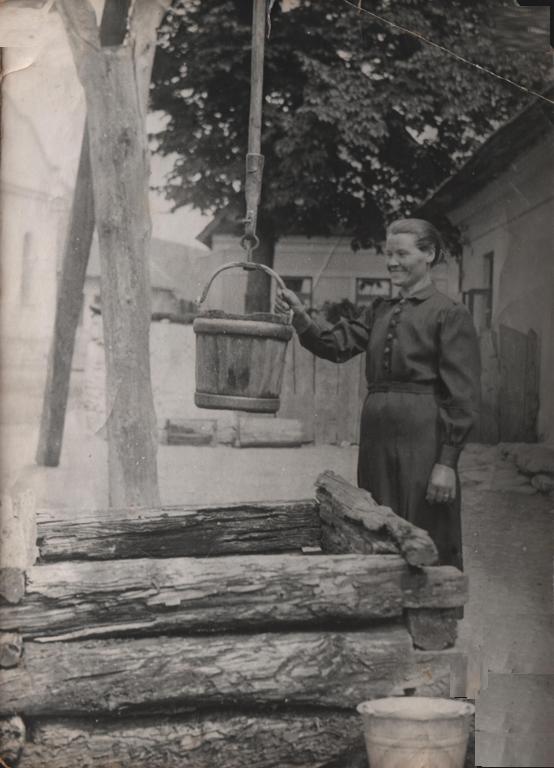 Mária Štepitová naberá vodu  za studne pred ich domom - fotoarchiv:Anka Dideková - 50-te roky